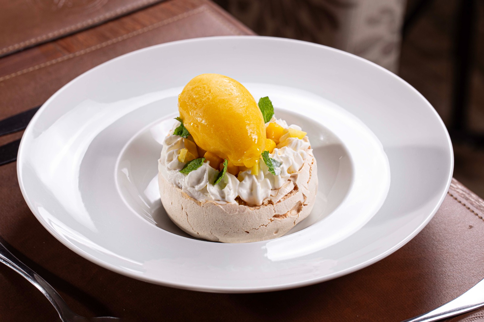 Pavlova recheada com chantily e frutas amarelas